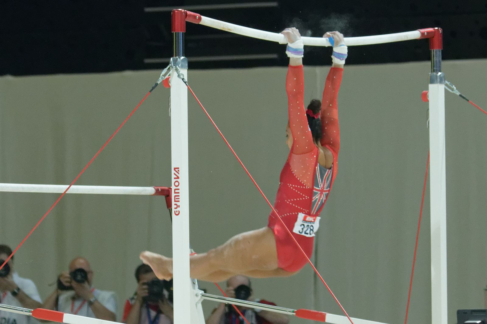 A gymnast swinging on the uneven bars at a championship